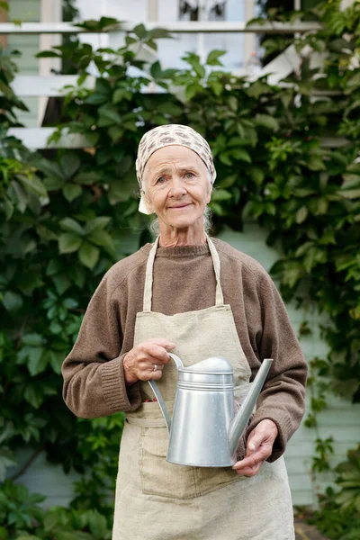 Happy Senior Female Gardener Apron Holding Watering Pot While Standing — Stock Photo, Image