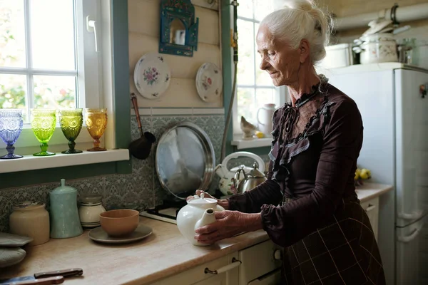 Serene Senior Woman Holding Teapot While Brewing Tea Her Guests — Stock Photo, Image
