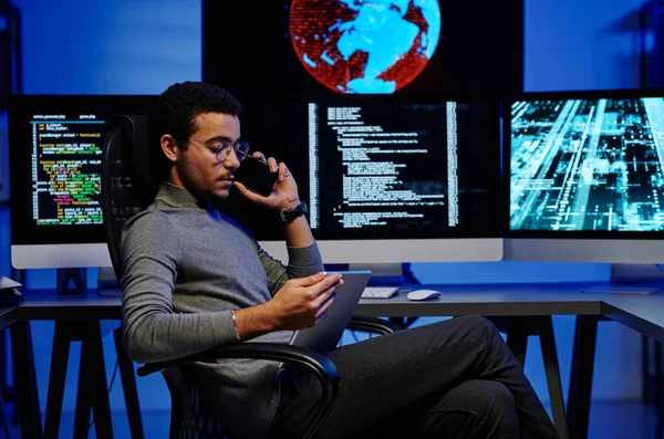 Vista Lateral Joven Programador Masculino Ocupado Hablando Teléfono Inteligente Mirando — Foto de Stock