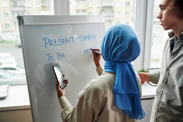 Обратный Вид Молодой Мусульманской Учительницы Объясняющей Многонациональному Парню Простое Напряжение — стоковое фото
