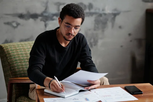 Jovem Empresário Sério Casualwear Fazendo Anotações Caderno Enquanto Sentado Poltrona — Fotografia de Stock