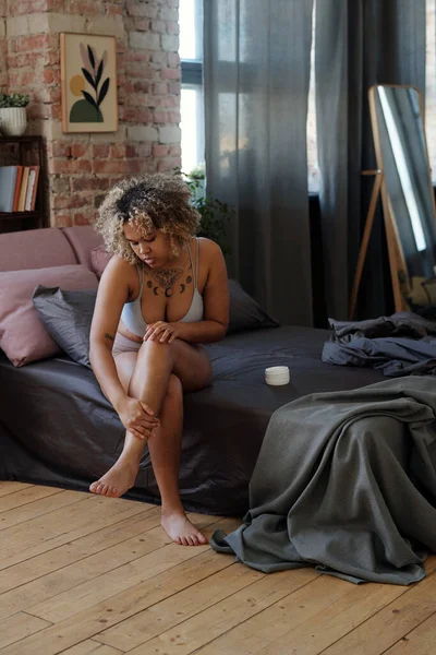 Çamaşırlı Genç Bir Kadın Çift Kişilik Yatakta Oturuyor Nemlendirici Sürerken — Stok fotoğraf
