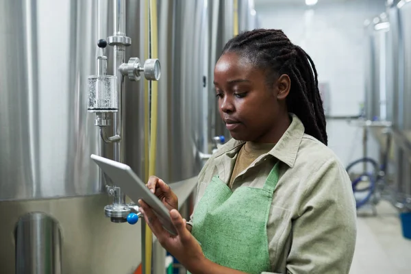 检查发酵过程时提到平板电脑的黑人年轻妇女 — 图库照片