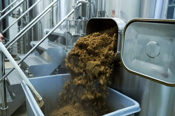 酿酒厂工人从罐中取出废谷物 — 图库照片