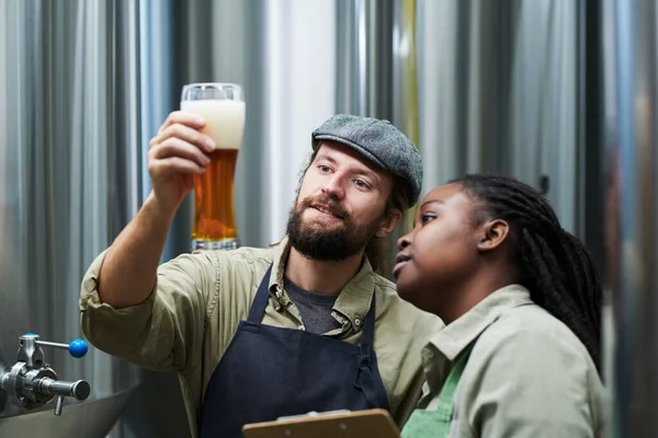 Leende Bryggeriarbetare Kontrollerar Ölskummets Tjocklek — Stockfoto
