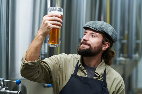 Χαρούμενος Γενειοφόρος Ιδιοκτήτης Ζυθοποιείου Κοιτάζοντας Ένα Ποτήρι Μπύρα Που Έφτιαξε — Φωτογραφία Αρχείου