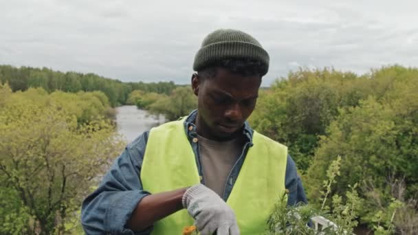 Portret Młodego Afroamerykańskiego Ogrodnika Trzymającego Skrzynkę Sadzonkami Stojącego Pierwszym Planie — Wideo stockowe