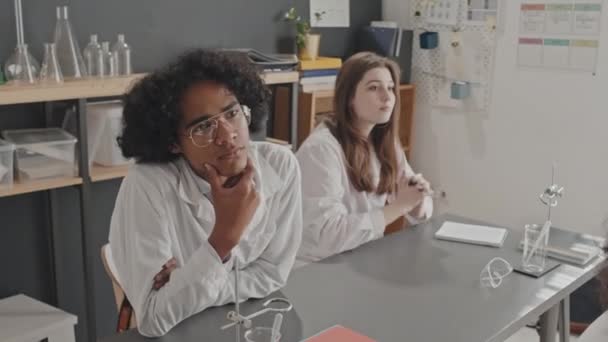 身穿白衣的非洲裔美国人和白人男女学生站在课桌前听讲座 — 图库视频影像
