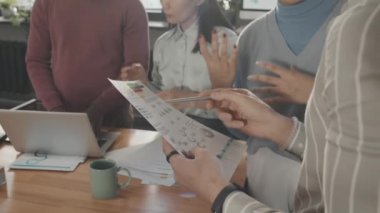 Orta Doğulu zeki bir adamın türbanlı Afrikalı Amerikalı bir kızla konuşması, belgeler üzerinde çalışması, gülmesi.