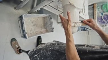 Atölyede çalışırken protez bacak soketi için alçı şeklindeki maluliyet şekillendiren tanınmayan adamın dikey yüksek açısı