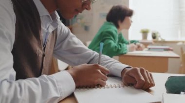Not defterine yazı yazan, gündüzleri sınıfta oturan Afro-Amerikan bir gencin...