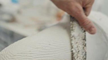 Keski kullanarak protez uzuv oluşturan tanınmayan bir zanaatkarın yakın plan çekimi.