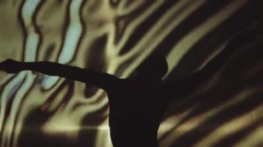 Tanımlanamayan genç bir adamın modern dans gösterisinin arka plan çekimi, arka planda soyut aydınlatma