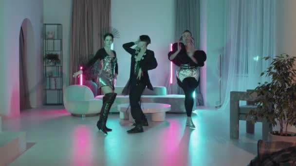 在霓虹灯下的现代公寓里 穿着未来派服装跳舞时尚的美女和小伙子们的长镜头 — 图库视频影像