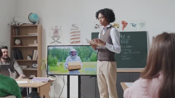 中等长角的黑人向同学们展示蜜蜂的教育视频 — 图库视频影像