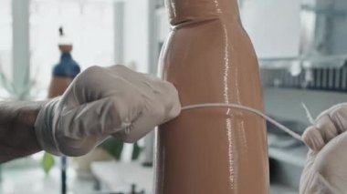 Tanımlanamayan bir adamın insan uzvuna sıvı plastik yayarak bacak protezi için soket oluşturması.