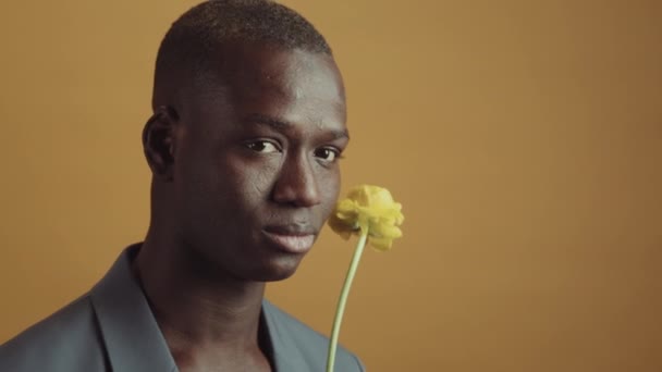 Close Portret Romantycznego Czarnego Człowieka Eleganckiej Kurtce Trzymając Żółty Kwiat — Wideo stockowe