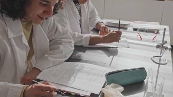 Вид Зверху Вниз Обрізаних Студентів Медичних Сукнях Сидять Шкільним Столом — стокове відео
