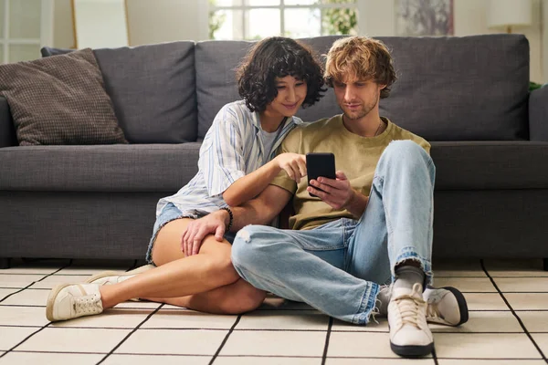 Junge Frau Zeigt Auf Handybildschirm Während Sie Mit Ihrem Mann — Stockfoto