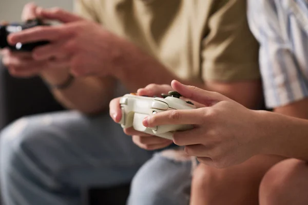 余暇にビデオゲームをプレイしながらゲームパッドでボタンを押す若い男と女の手のクローズアップ — ストック写真