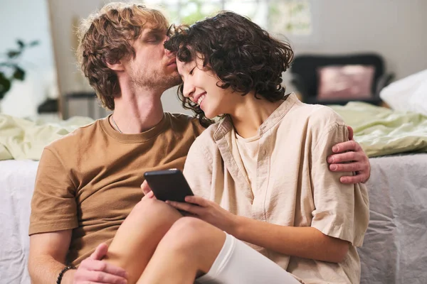 Jovem Abraçando Sua Esposa Com Telefone Celular Tocando Sua Testa — Fotografia de Stock