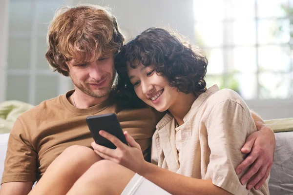 Młoda Szczęśliwa Kobieta Jej Mąż Patrząc Ekran Telefonu Komórkowego Przechowywane — Zdjęcie stockowe