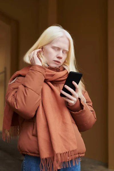 Rahat Kahverengi Ceketli Sıcak Eşarplı Genç Bir Kadın Cep Telefonuyla — Stok fotoğraf