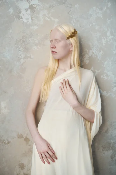 拍照时 身穿白衣的年轻沉着的白化病妇女站在大理石墙边 紧闭双眼 — 图库照片