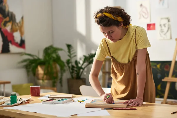 テーブルの上に曲げられ 紙にクレヨンで描く若いかなり職人は スタジオで新しい傑作や作品を作成しながら — ストック写真