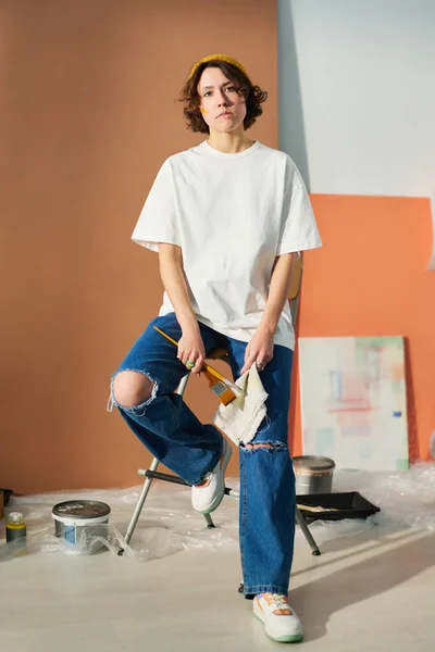 Jovem Pintora Feminina Criativa Casualwear Segurando Pincéis Enquanto Senta Cadeira — Fotografia de Stock