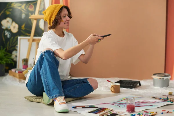 Jovem Pintora Feminina Criativa Feliz Com Smartphone Sentado Chão Tirando — Fotografia de Stock