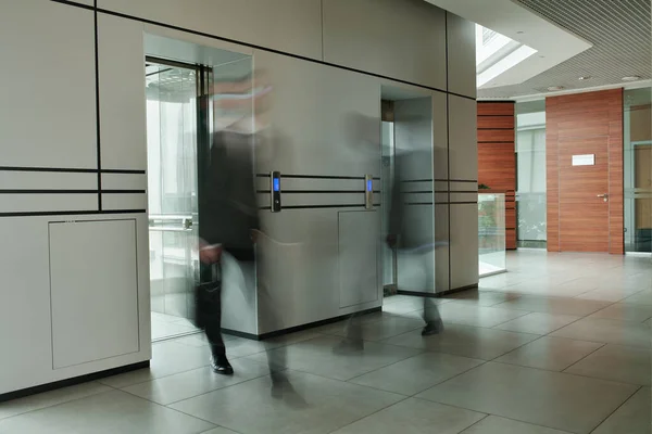 현대식 사무실 중앙에 복도의 유리문 엘리베이터를 사업가 — 스톡 사진