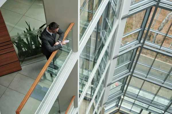 Powyżej Ujęcia Młodego Eleganckiego Biznesmena Smsującego Smartfonie Balustradami Piętrze Wysokiego — Zdjęcie stockowe
