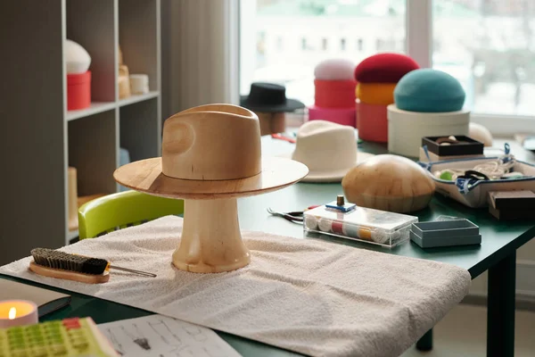 现代时装设计师的工作场所和销售手工制作的帽子和贝雷帽的小手工艺店店主 — 图库照片