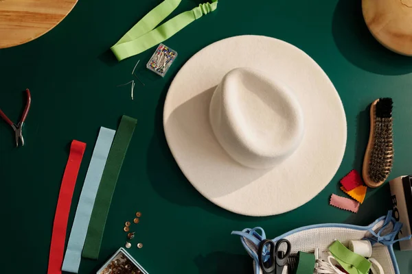 Beyaz Keçeli Şapkanın Üst Görüntüsü Çeşitli Tekstil Örnekleri Arasında Küçük — Stok fotoğraf