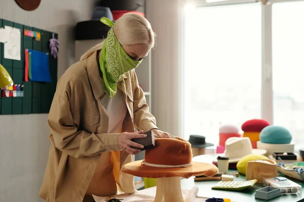 Молодая Креативная Женщина Банданой Лице Полирует Новую Фетровую Шляпу Ручной — стоковое фото