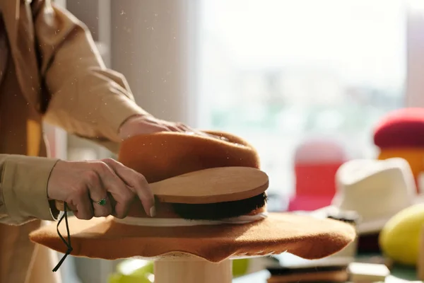 Kahverengi Keçeli Şapkanın Yüzeyindeki Toz Zerrelerini Fırçalarken Yeni Parçayı Bitiren — Stok fotoğraf