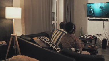 Romantik bir çiftin oturma odasında oturup zombilerle ilgili bir film izlemesi ve şarap içmesi.