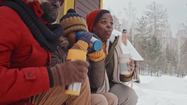 현대인 아프리카 미국인 현관에 앉아서 뜨거운 마시고 눈내리는 겨울에 수다를 — 비디오