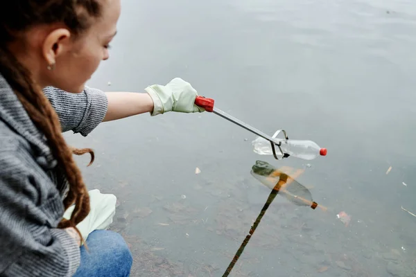 Młoda Kobieta Pomocą Specjalnego Narzędzia Podnoszenia Plastikowych Butelek Jeziorze — Zdjęcie stockowe