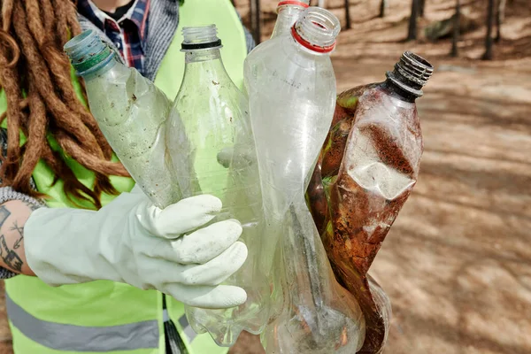 Ręce Wolontariuszki Trzymającej Wiele Brudnych Plastikowych Butelek Które Znalazła Lesie — Zdjęcie stockowe