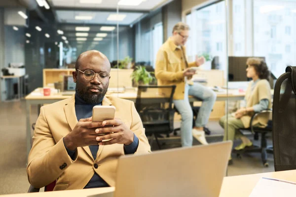 Poważny African American Manager Pomocą Smartfona Podczas Siedzenia Miejscu Pracy — Zdjęcie stockowe