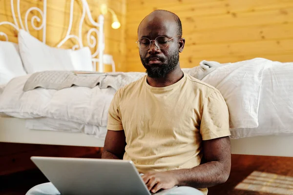 Serieuze Mannelijke Freelancer Met Laptop Zitten Vloer Van Een Tweepersoonsbed — Stockfoto