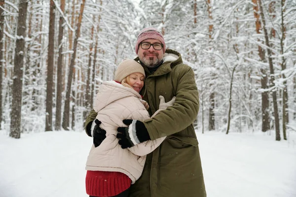Šťastný Starší Muž Objímající Svou Ženu Teplé Zimní Bundě Čepici — Stock fotografie
