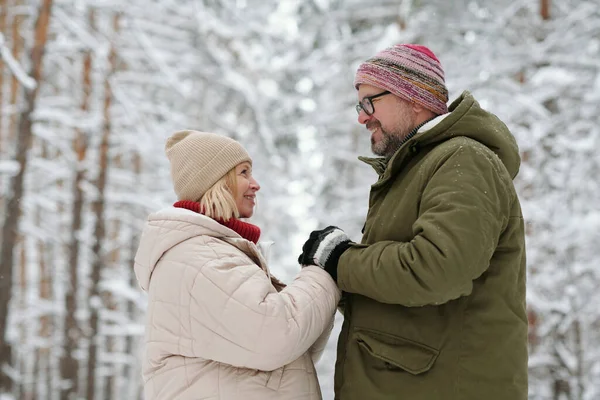 Dojrzała Para Heteroseksualna Patrzy Siebie Trzymając Się Ręce Zimowym Lesie — Zdjęcie stockowe