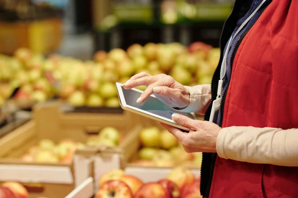 Zbliżenie Dojrzałej Administratorki Supermarketu Czerwonym Mundurze Przy Użyciu Tabletu Podczas — Zdjęcie stockowe
