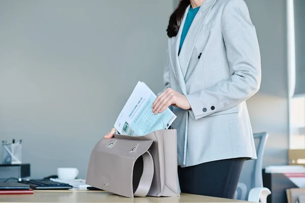仕事の後オフィスを出るときにグレーの革のハンドバッグに財務文書を入れて若いエレガントなビジネス女性のクローズアップ — ストック写真