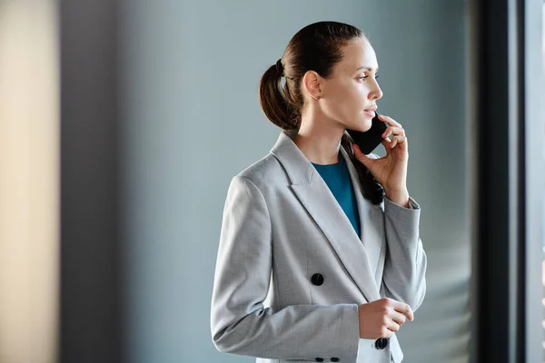 Junge Seriöse Geschäftsfrau Formalbekleidung Hält Smartphone Ohr Während Sie Büro — Stockfoto
