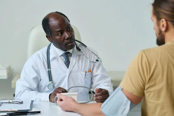 Erfaren Afroamerikansk Manlig Läkare Som Använder Tonometer Vid Mätning Blodtrycket — Stockfoto