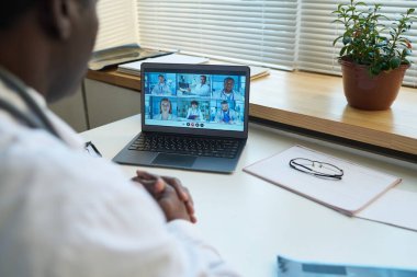 Sosyal hizmet uzmanları için webinar 'da yer alan bir grup kültürler arası genç sanal sağlık asistanıyla birlikte dizüstü bilgisayara odaklanın